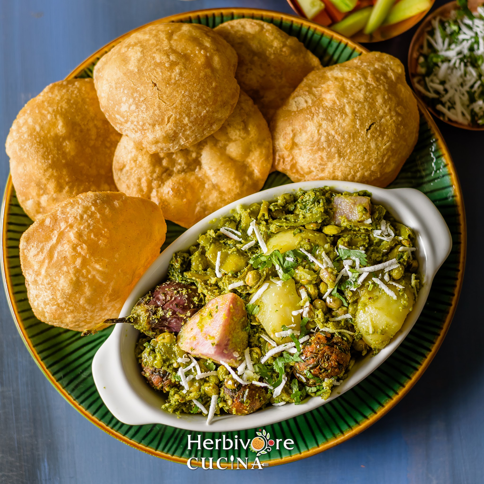 An oval platter filled with undhiyu and served with puris and some salad on the side. 