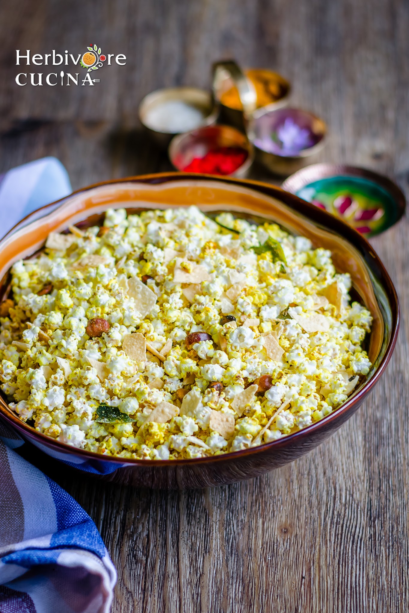 Jowar Dhani Chivda in a brown bowl with Holi pooja ingredients around it. 