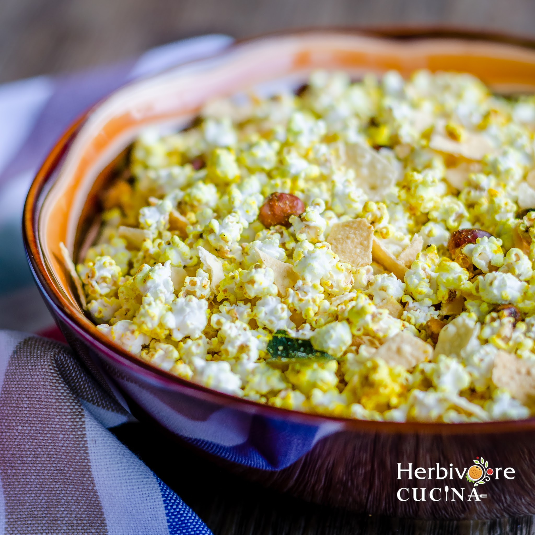 A bowl full of roasted jowar dhani and papad chivda with a white napkin below it. 