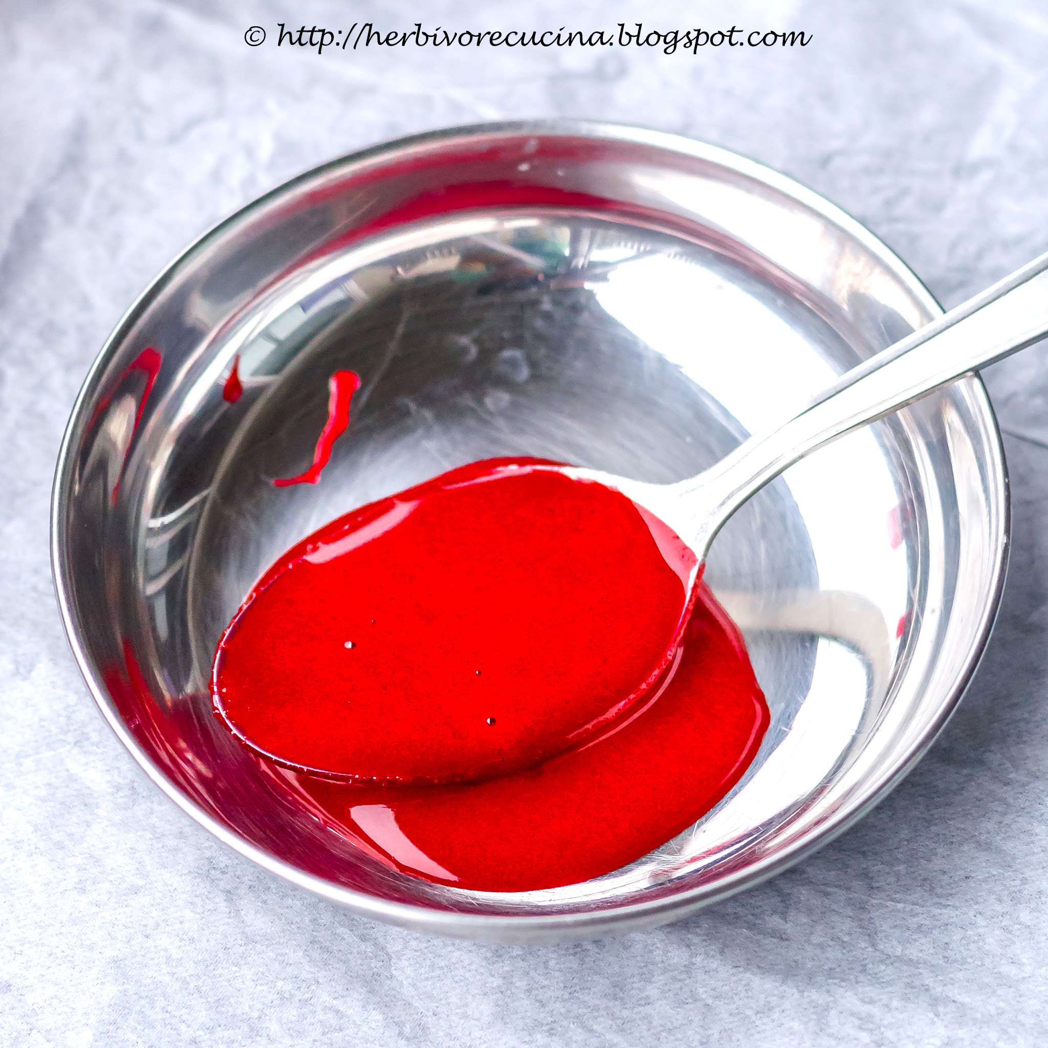 A plate with fake edible blood in a spoon.