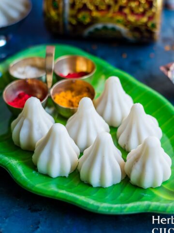 Ukadiche Modak placed on a green plate with more puja items on the side.