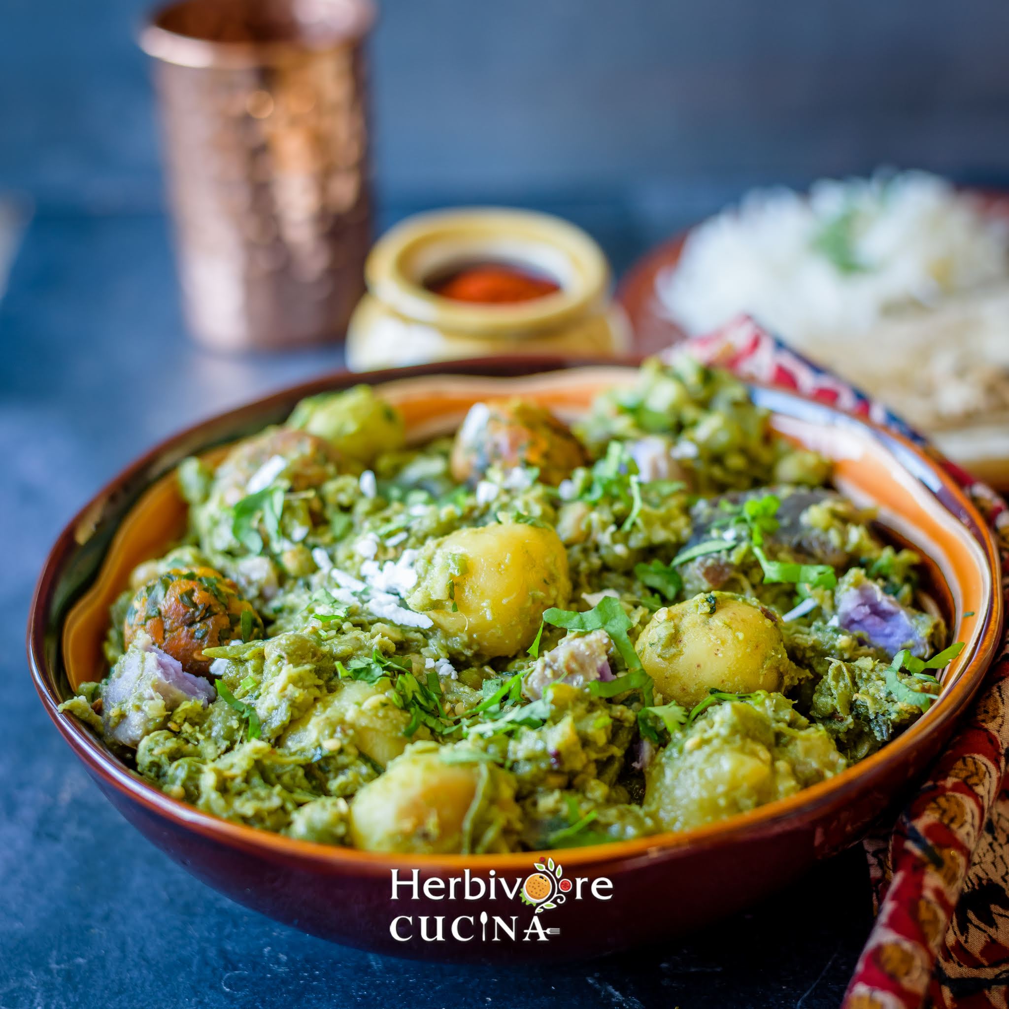 Side view of a brown bowl filled with undhiyu; served with steamed rice and chutney on the side. 