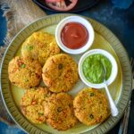 Air Fryer Quinoa patty in a plate with chutney and ketchup on the side.