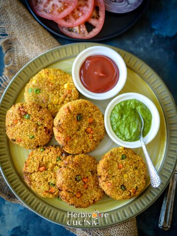 Air Fryer Quinoa patty in a plate with chutney and ketchup on the side.