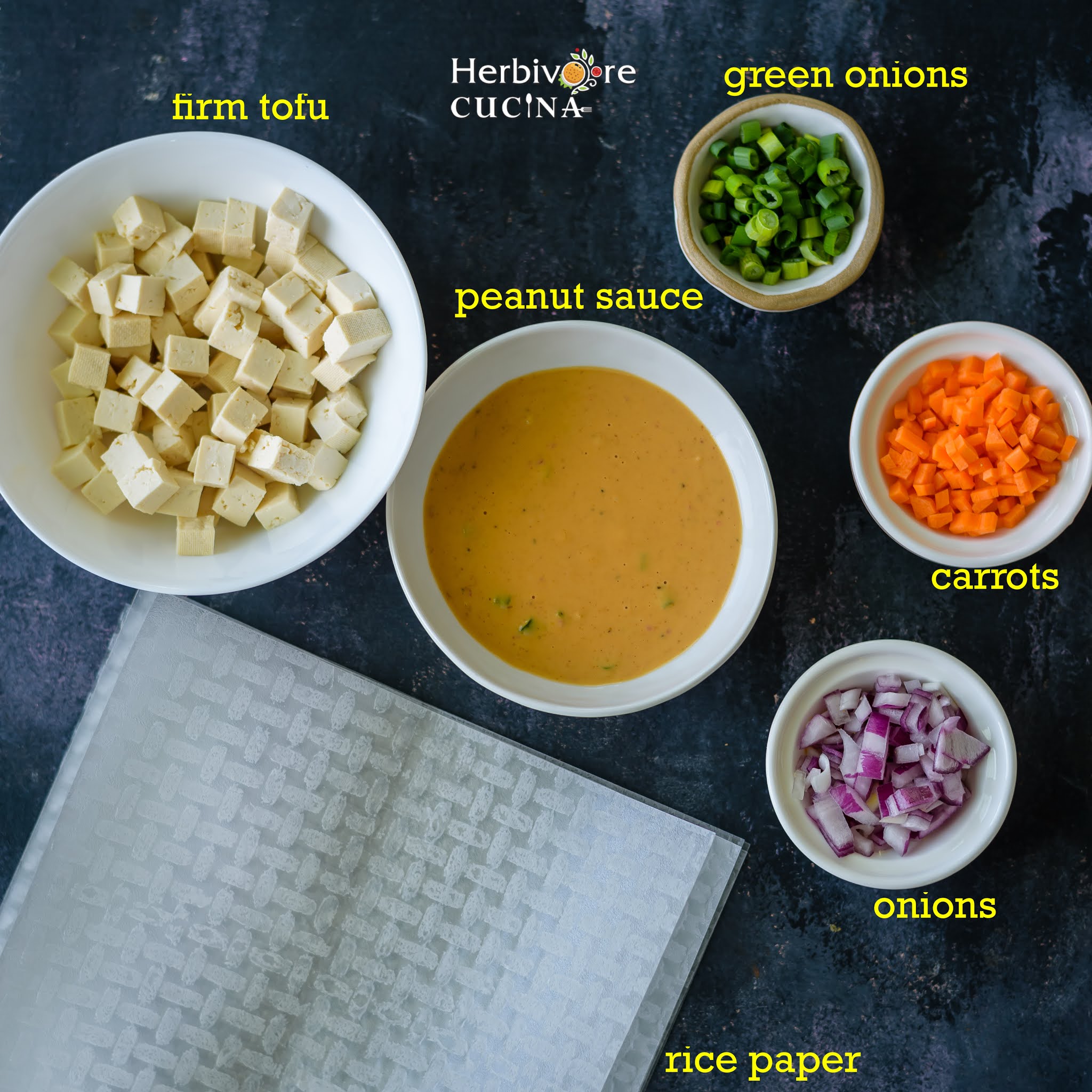 Rice paper nachos ingredients; rice paper, tofu, sauce and vegetables arranged on a black board. 
