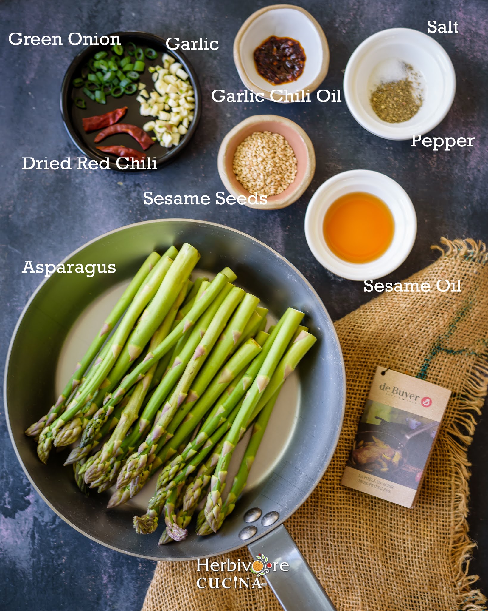 Ingredients for asparagus stir fry in small bowls on a dark background. 