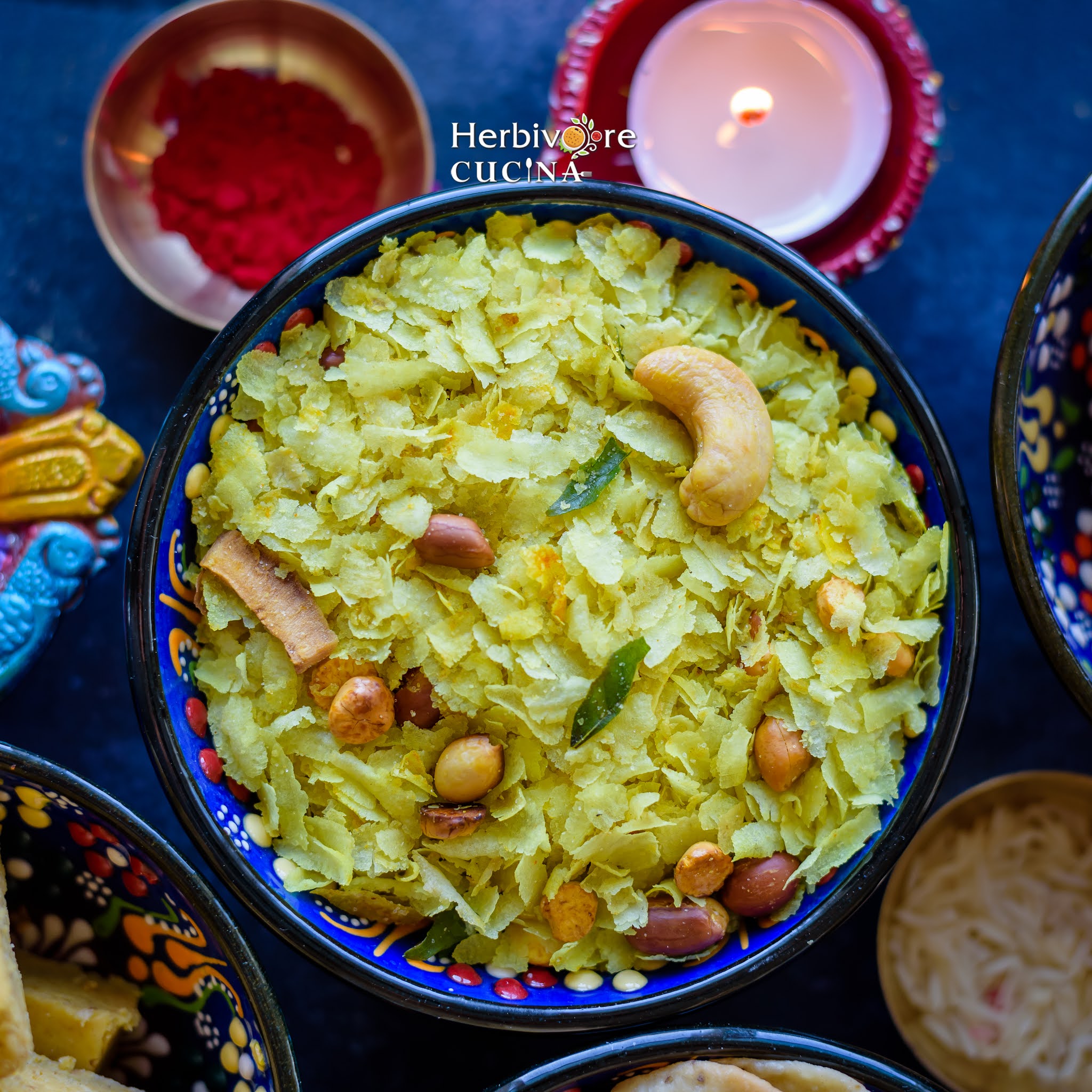 A blue bowl with Roasted Poha Chivda with diwali sweets and diya around it. 