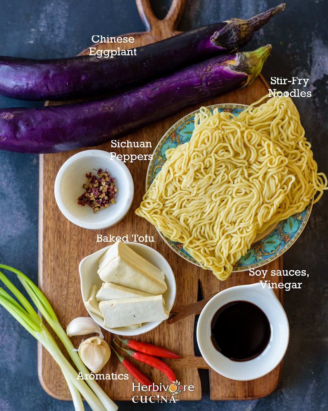 Ingredients for Sichuan Eggplant Noodles with tofu; noodles, tofu and seasonings on a wooden board. 