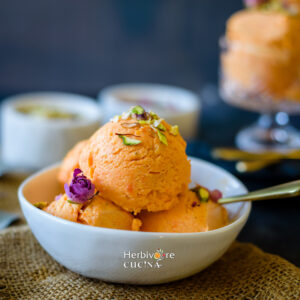 Gajar Halwa ice cream served in a bowl topped with rose and nuts.