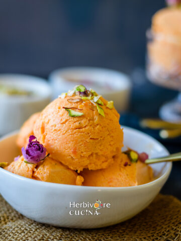 Gajar Halwa ice cream served in a bowl topped with rose and nuts.