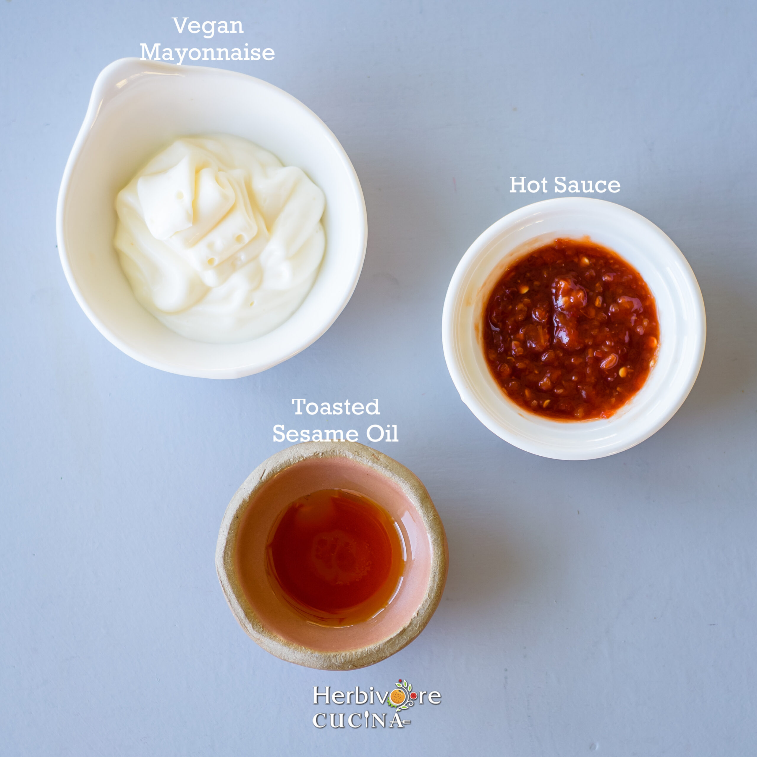 How to make poke sauce; Vegan mayonnaise, hot sauce and sesame oil on a gray background. 