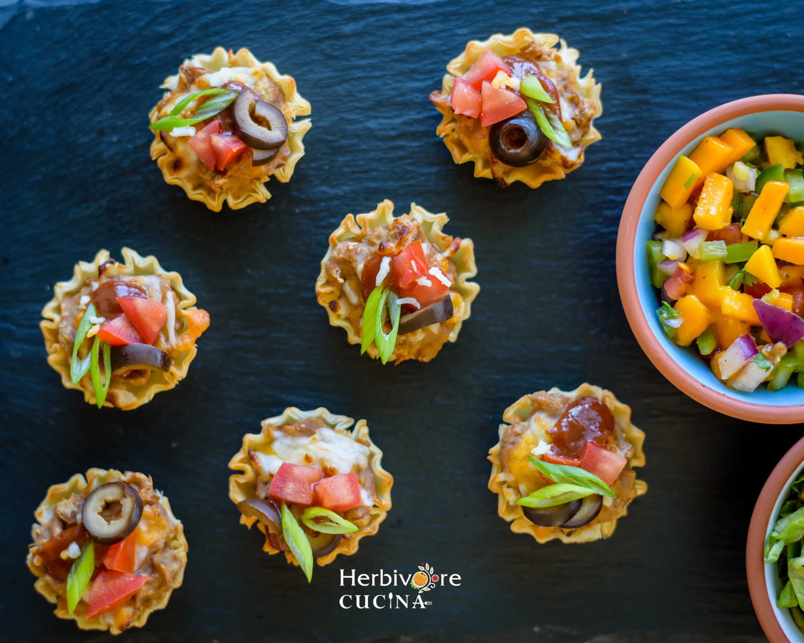 Mexican Pizza Cups on slate with mango salsa in a small cup on the side. 
