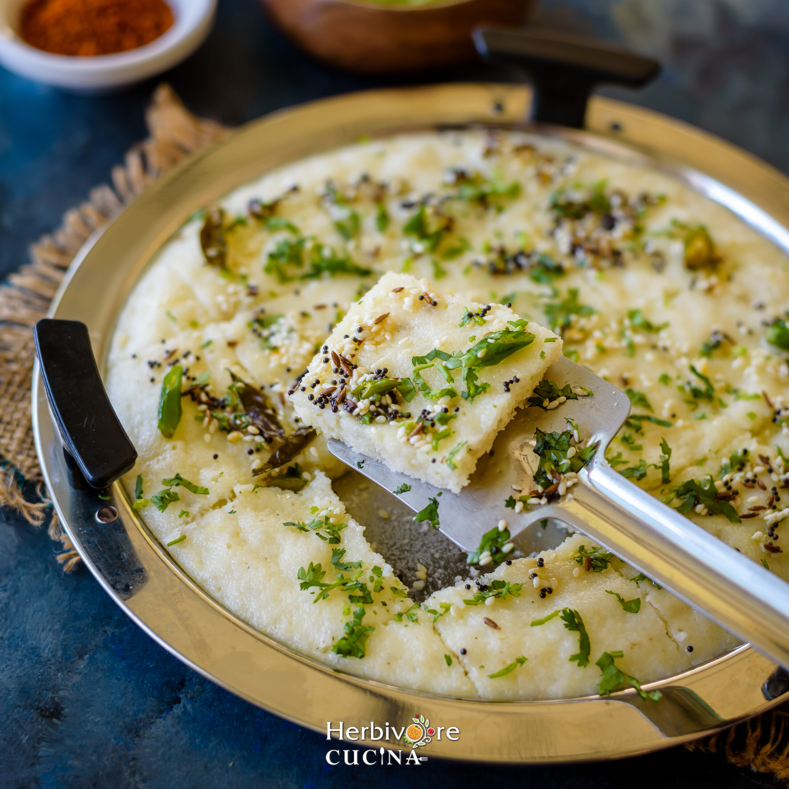 Steps to make rava dhokla; add tempering to dhokla and cut into squares. Serve with chutney. 