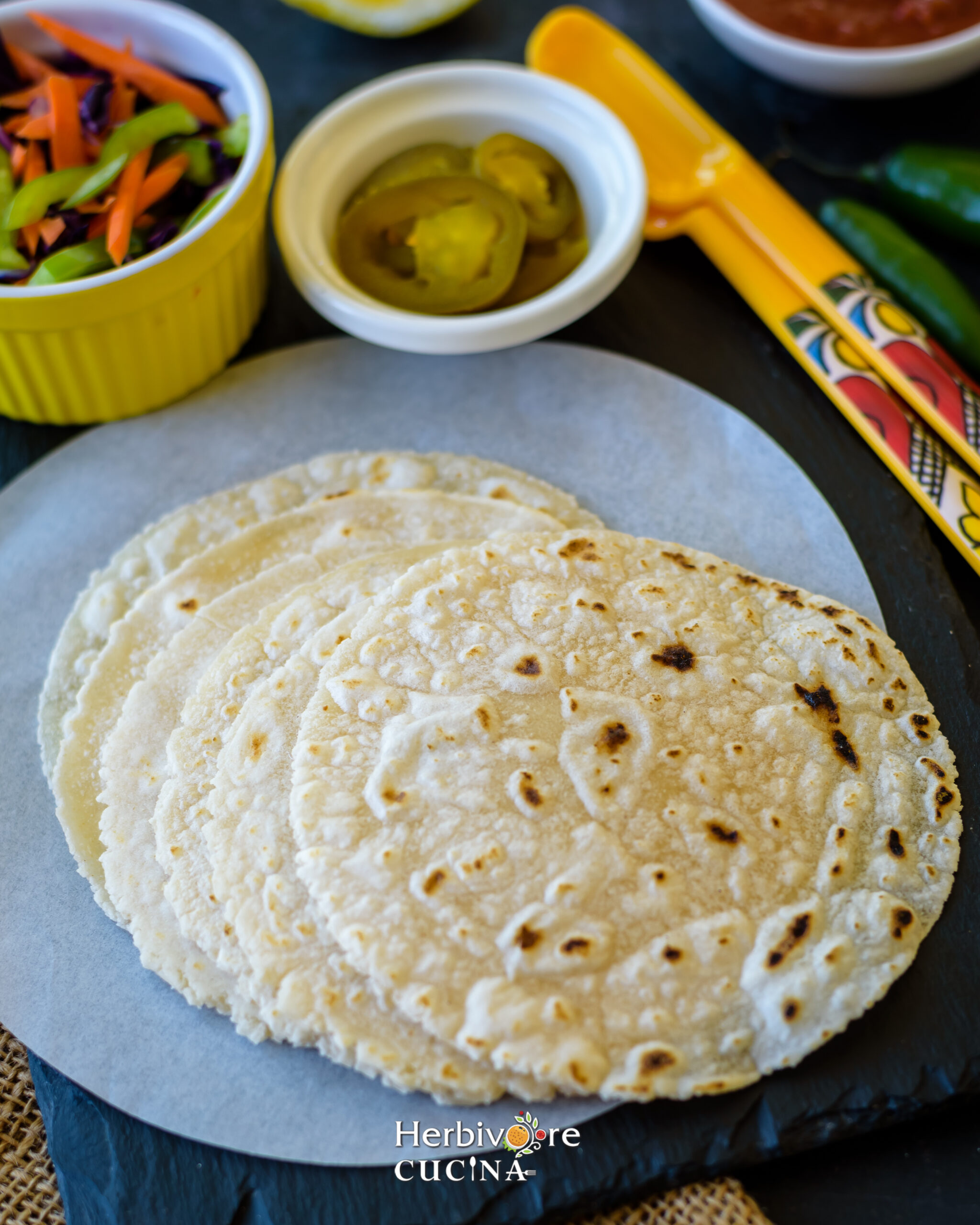 Cassava Flour gluten-free tortillas on a parchment paper with Mexican ingredients on the side. 
