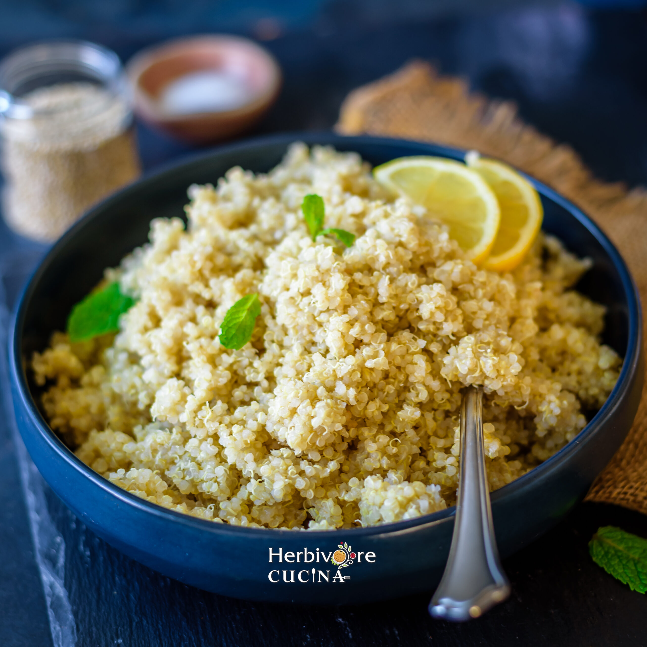 Angled view of quinoa cooked in the instant pot and plated in a blue bowl against a dark background. 