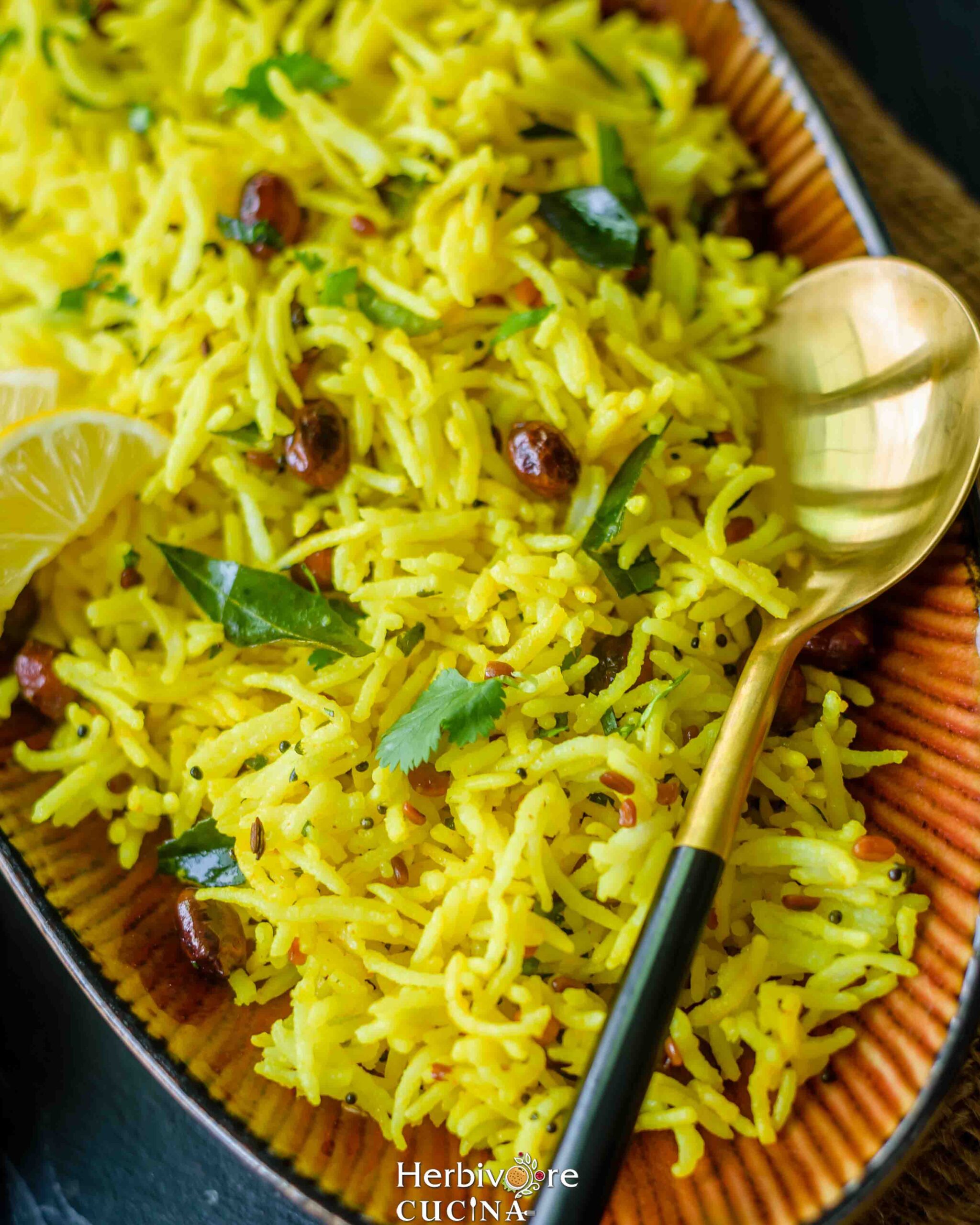 A platter full of lemon rice with peanuts, turmeric and other tempering ingredients.