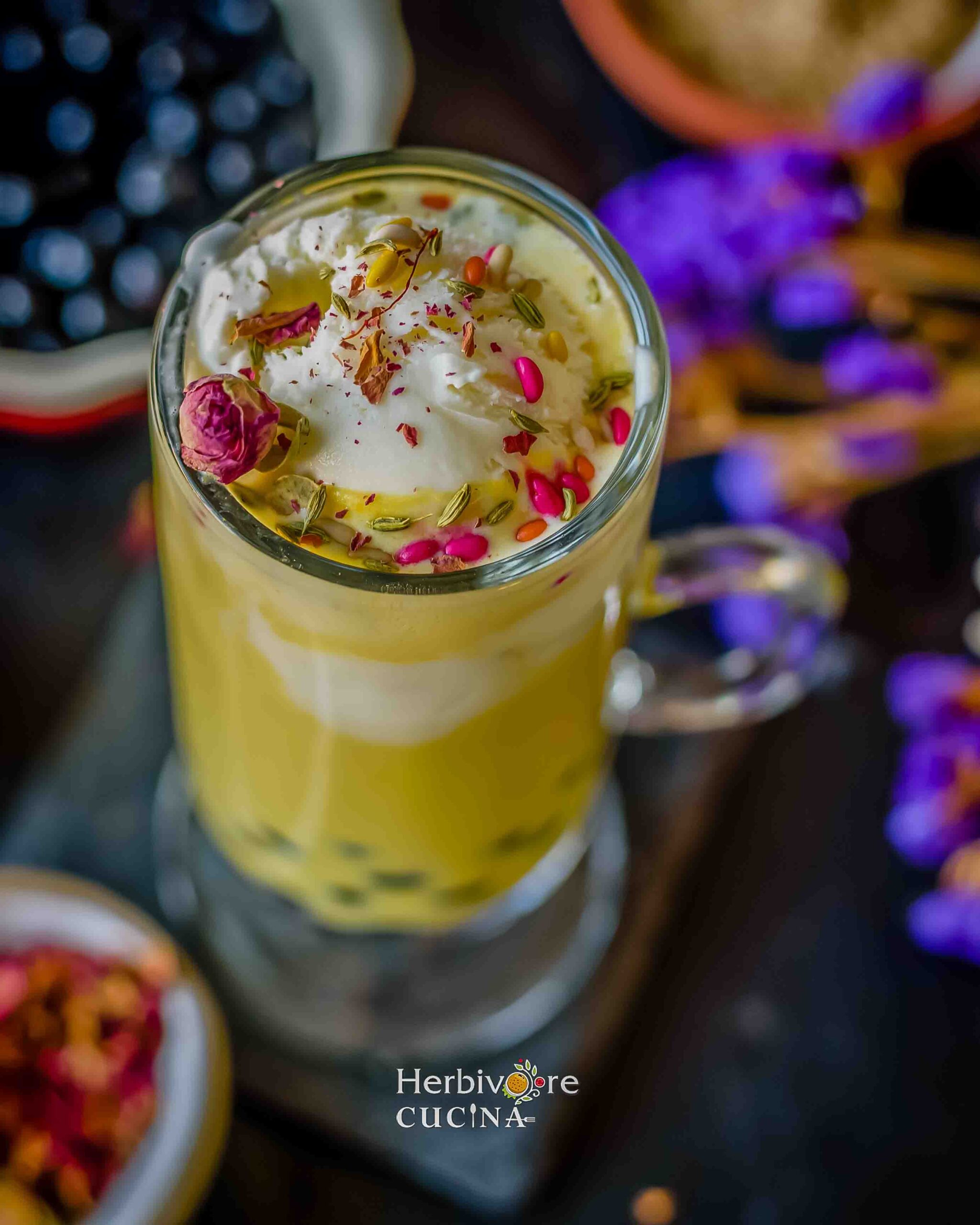 Top view of boba thandai with all the toppings like colored fennel and dried rose petals against a backdrop of dried flowers and boba.