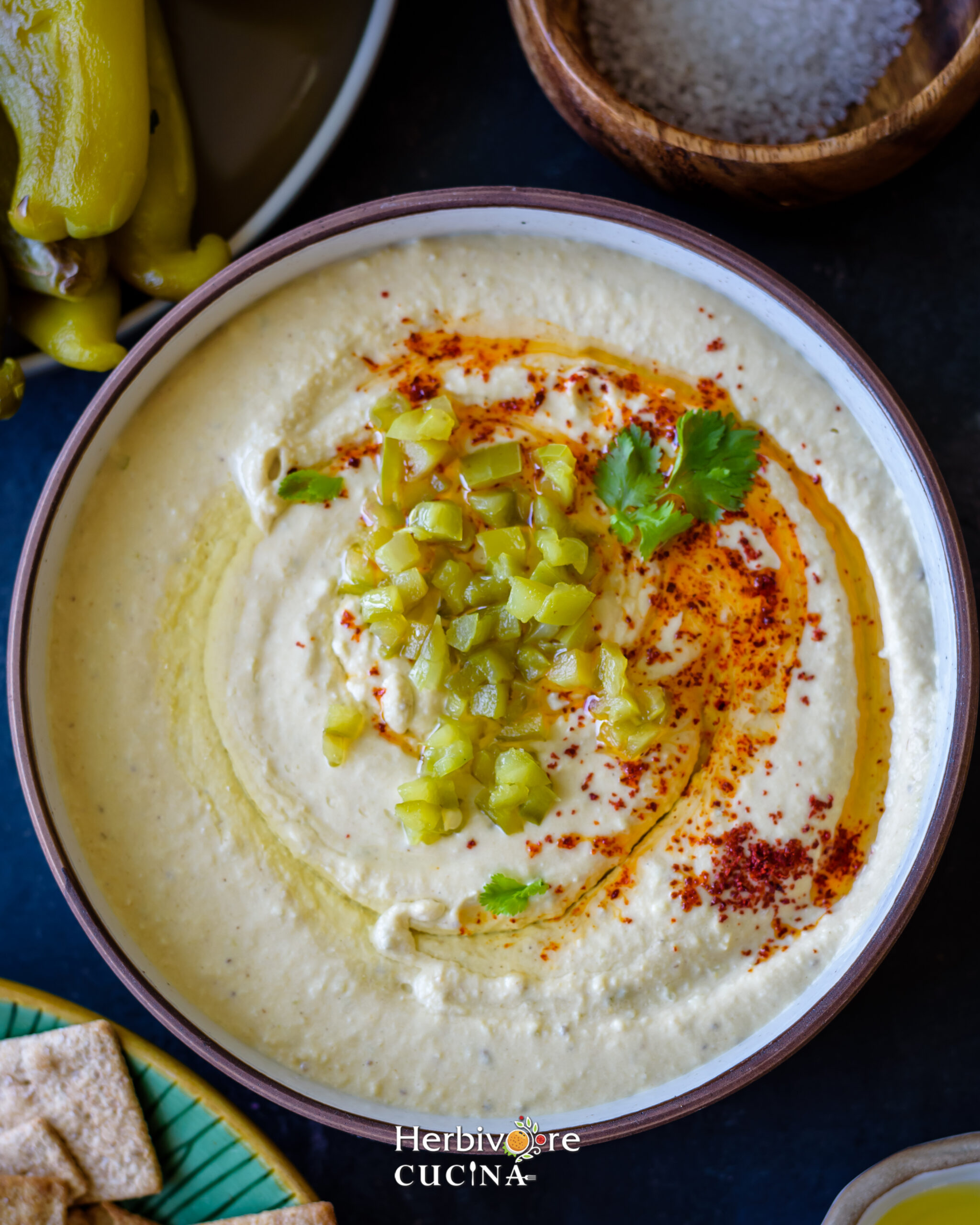 Top view of Hatch chile hummus in a bowl; topped with chile, paprika and olive oil. 