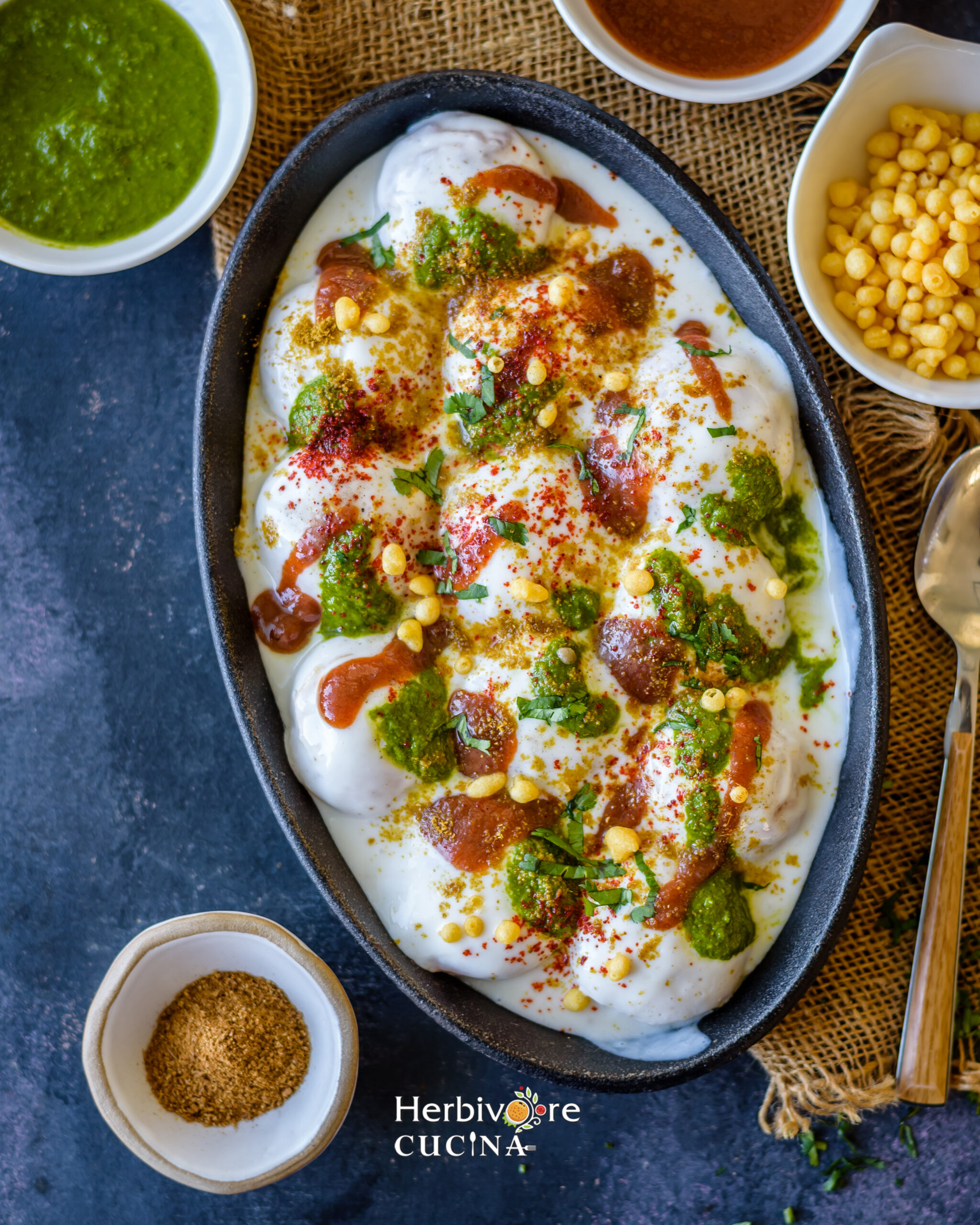 Instant Dahi Vada; fritters made with lentil and dunked in yogurt and toppings; served in black oval platter with toppings on the side. 