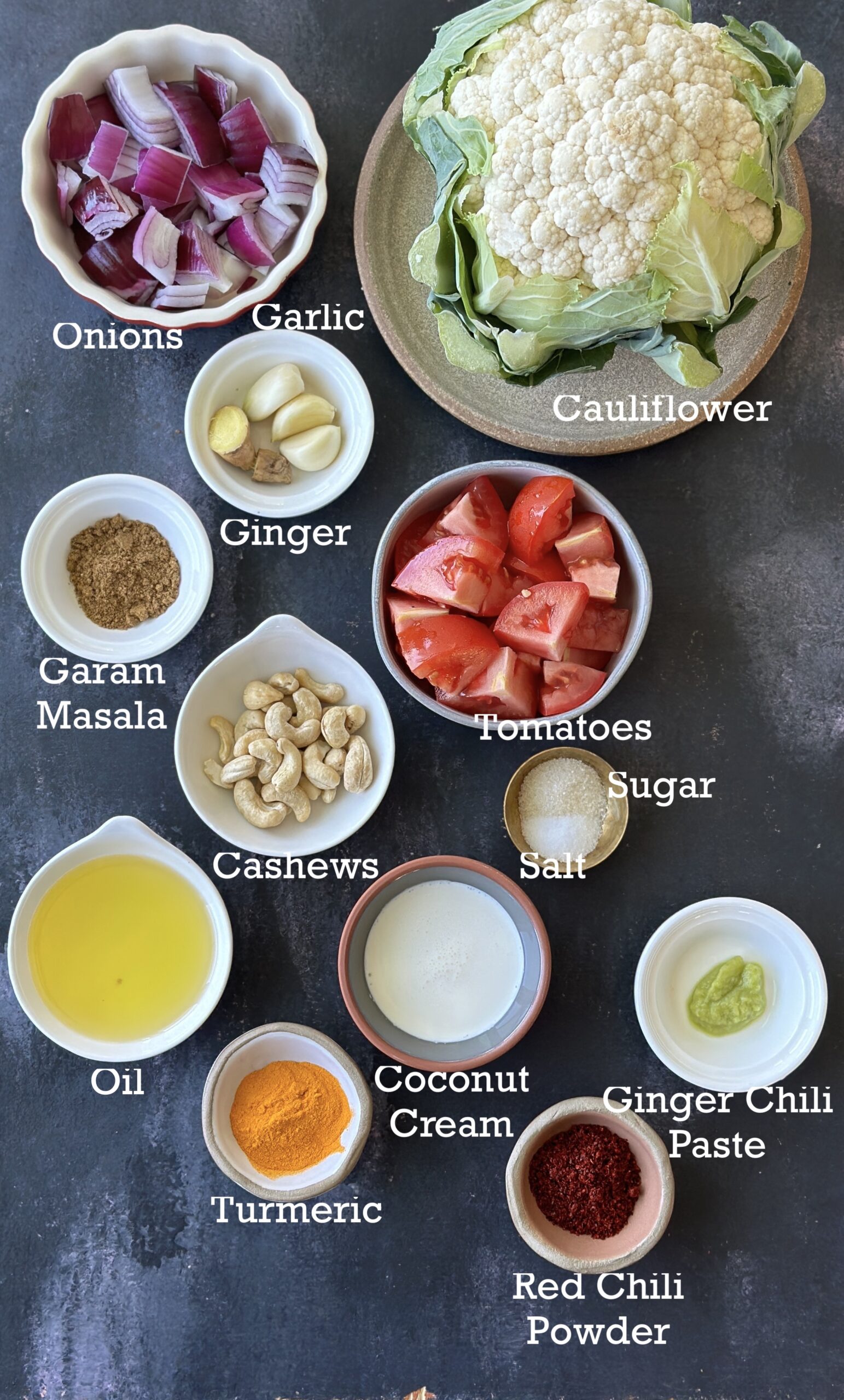 Ingredients for instant pot cauliflower arranged in containers on a black surface. 