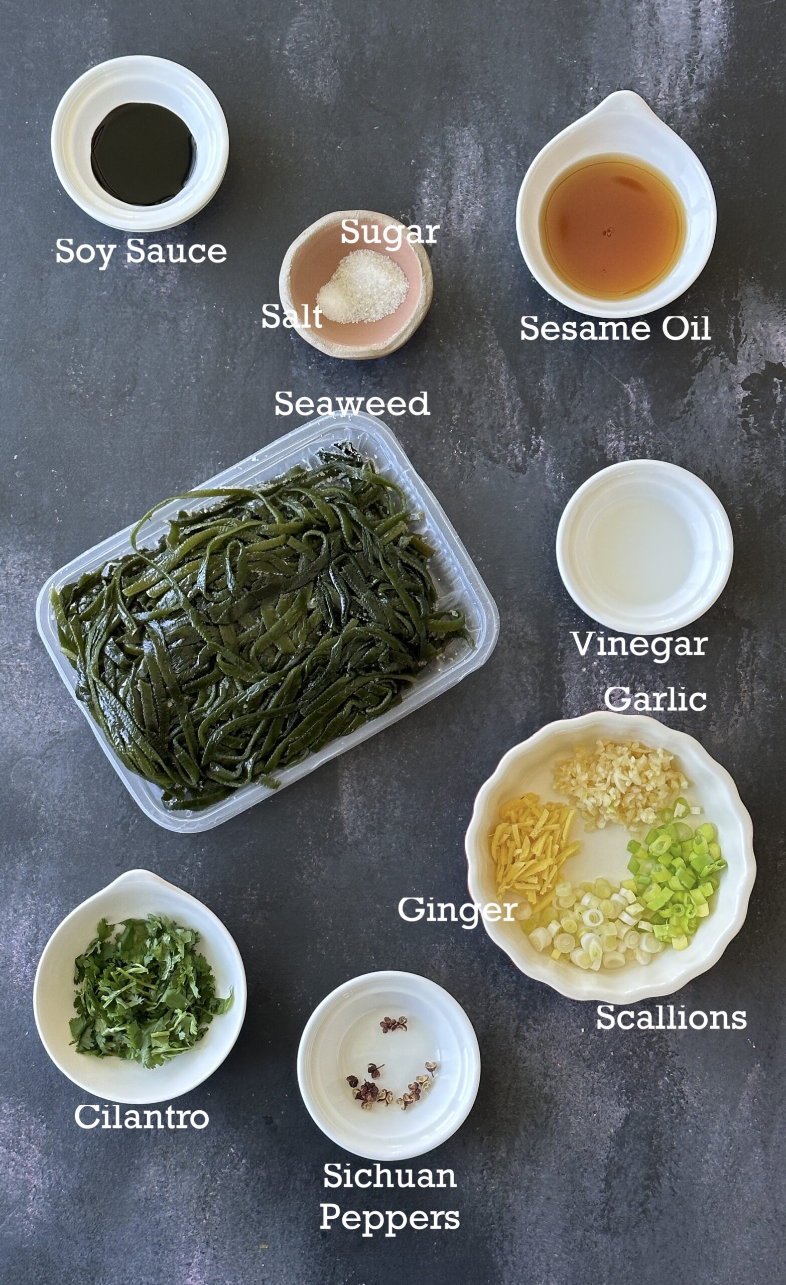 Ingredients of Chinese seaweed salad arranged on a gray background. 