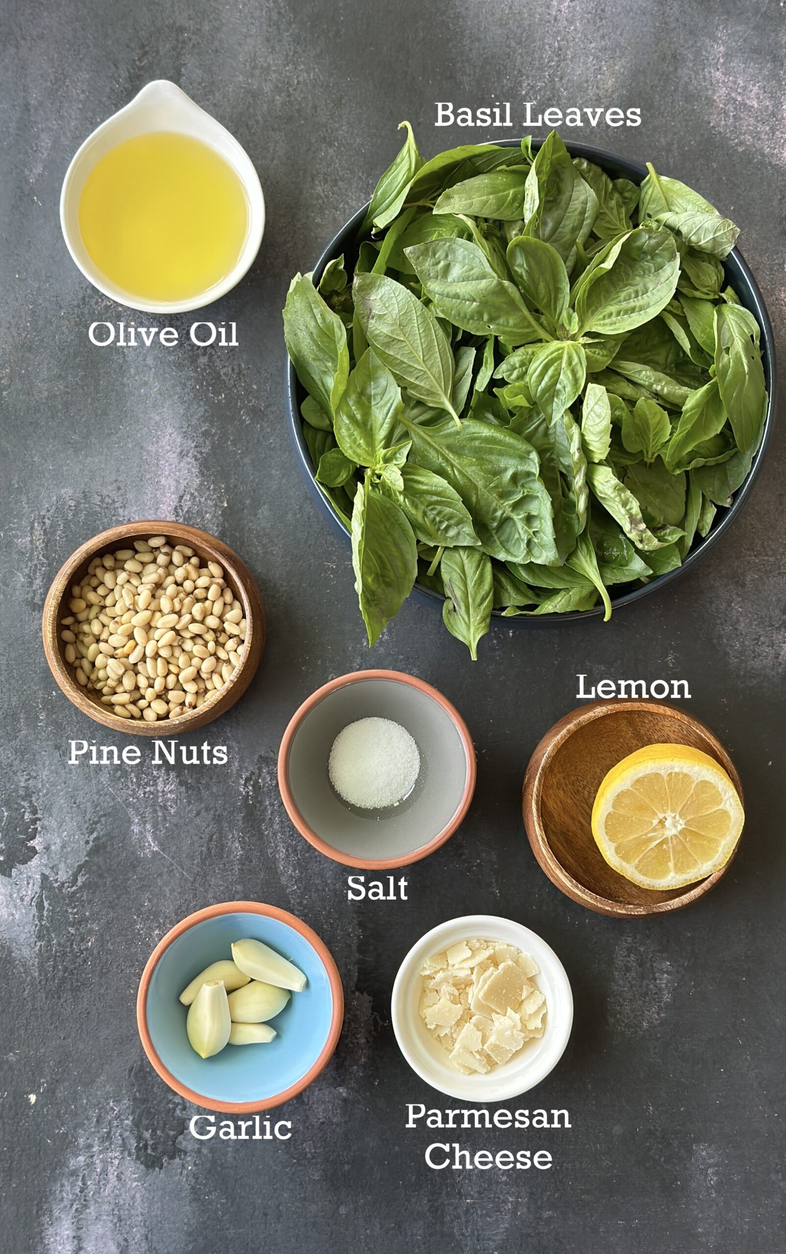 Ingredients for basil pesto arranged in small bowls. 