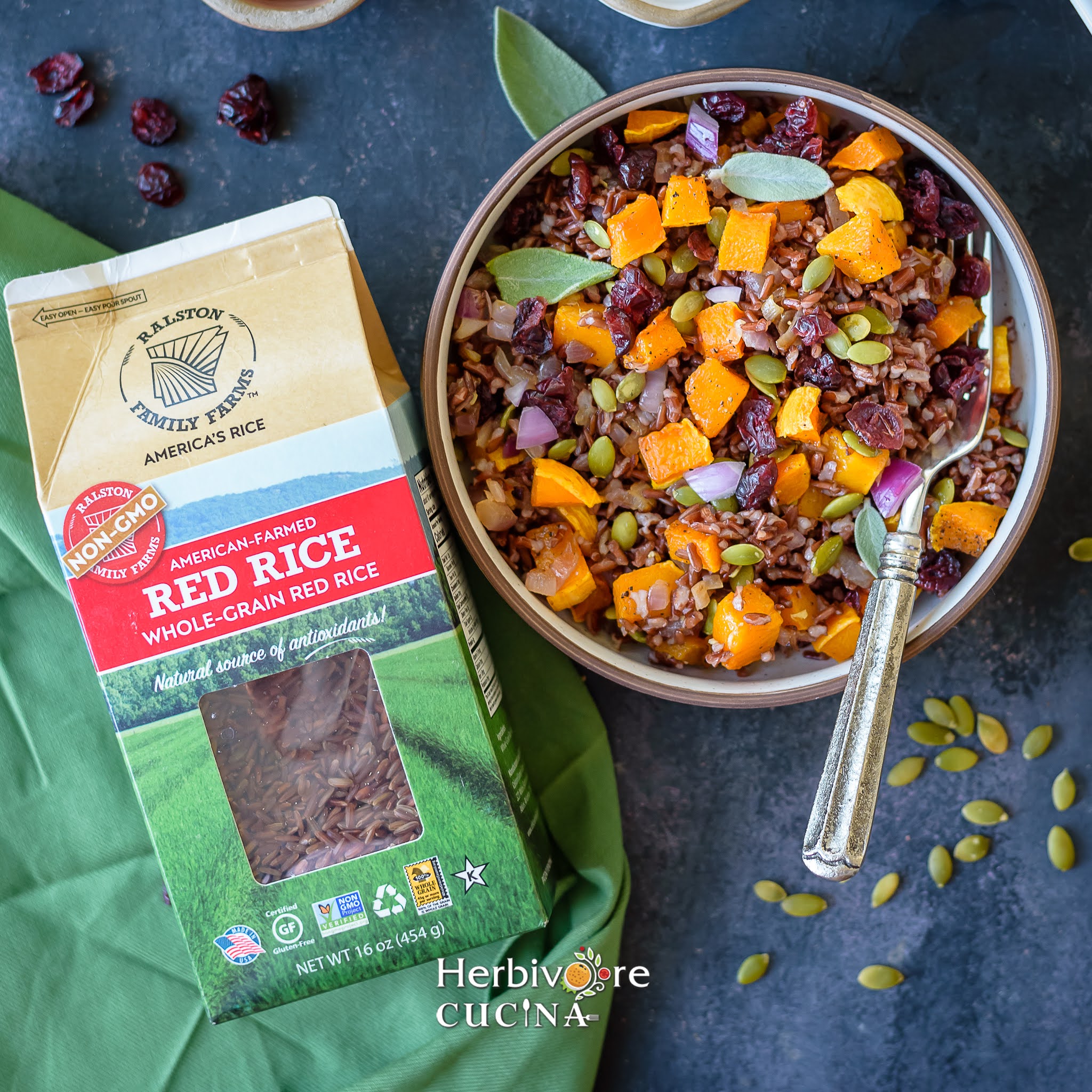 A bowl with red rice and butternut squash pilaf with a box of red rice beside it. 