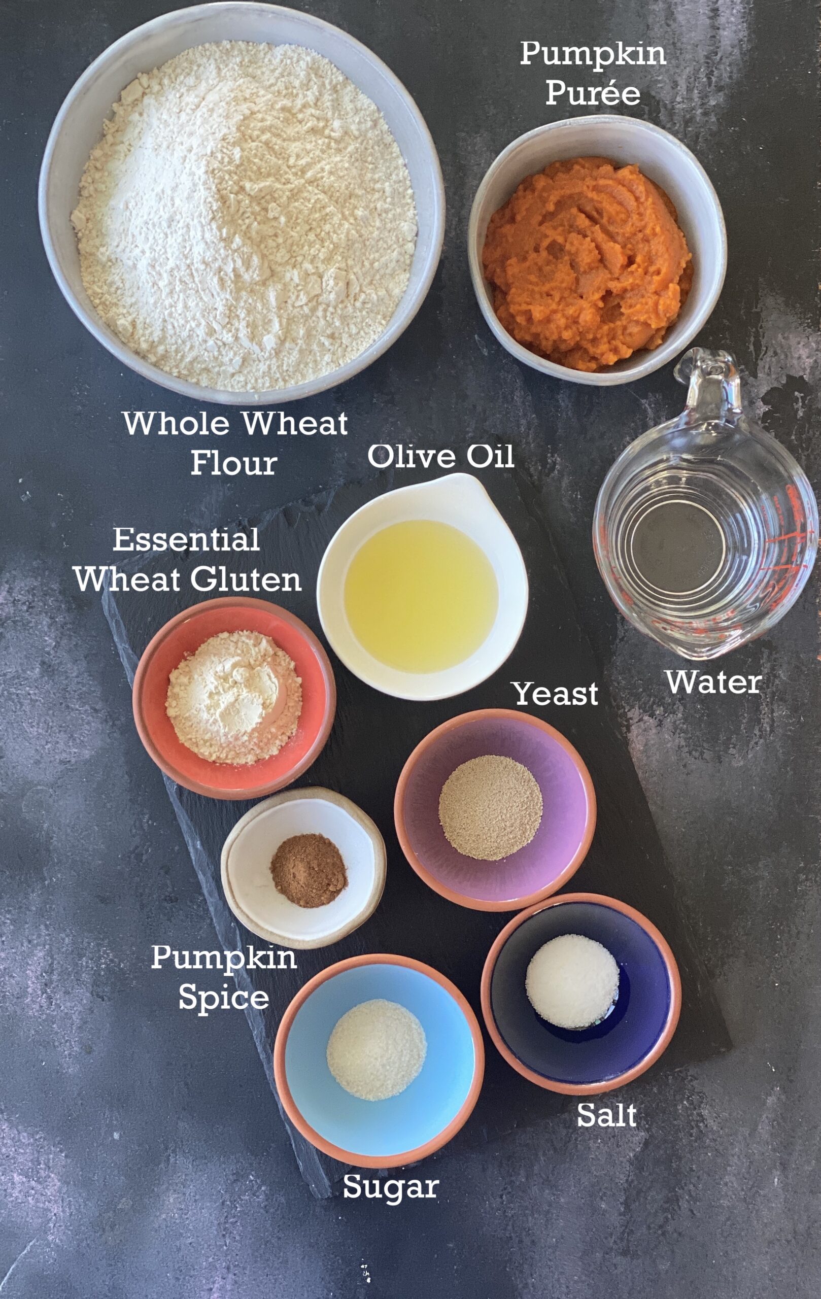 Ingredients for Vegan Pumpkin Rolls arranged on a board in small bowls. 