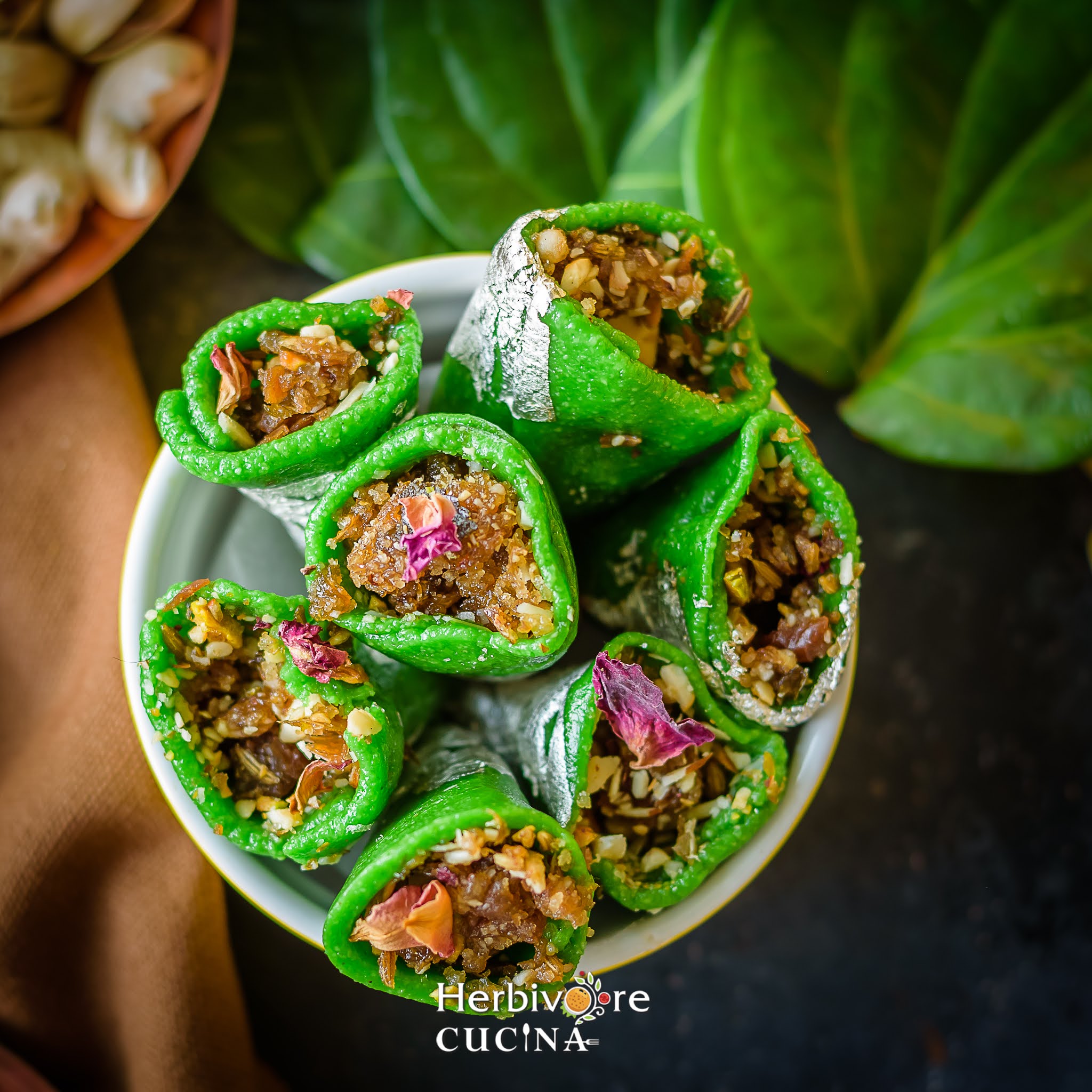Kaju paan filled with gulkand, nuts and cardamom powder in a bowl with nuts on the side. 