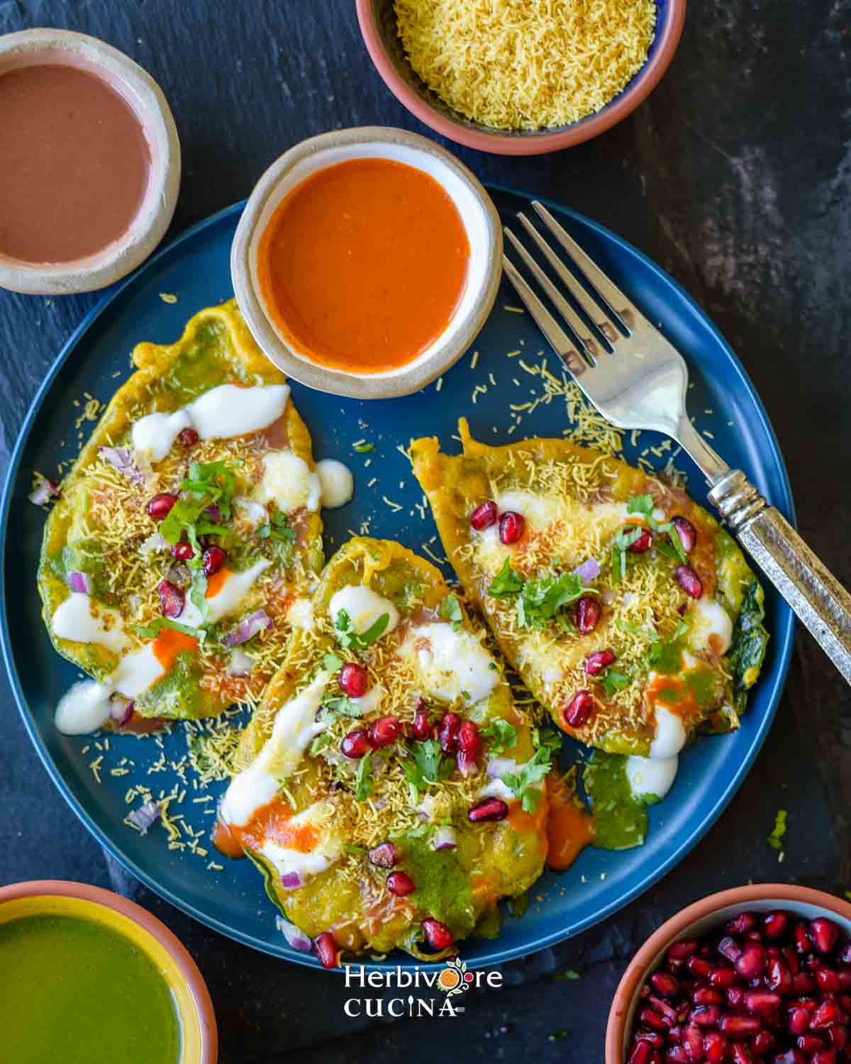 Paan Chaat served in a plate nad topped with chutneys, vegetables and toppings. 