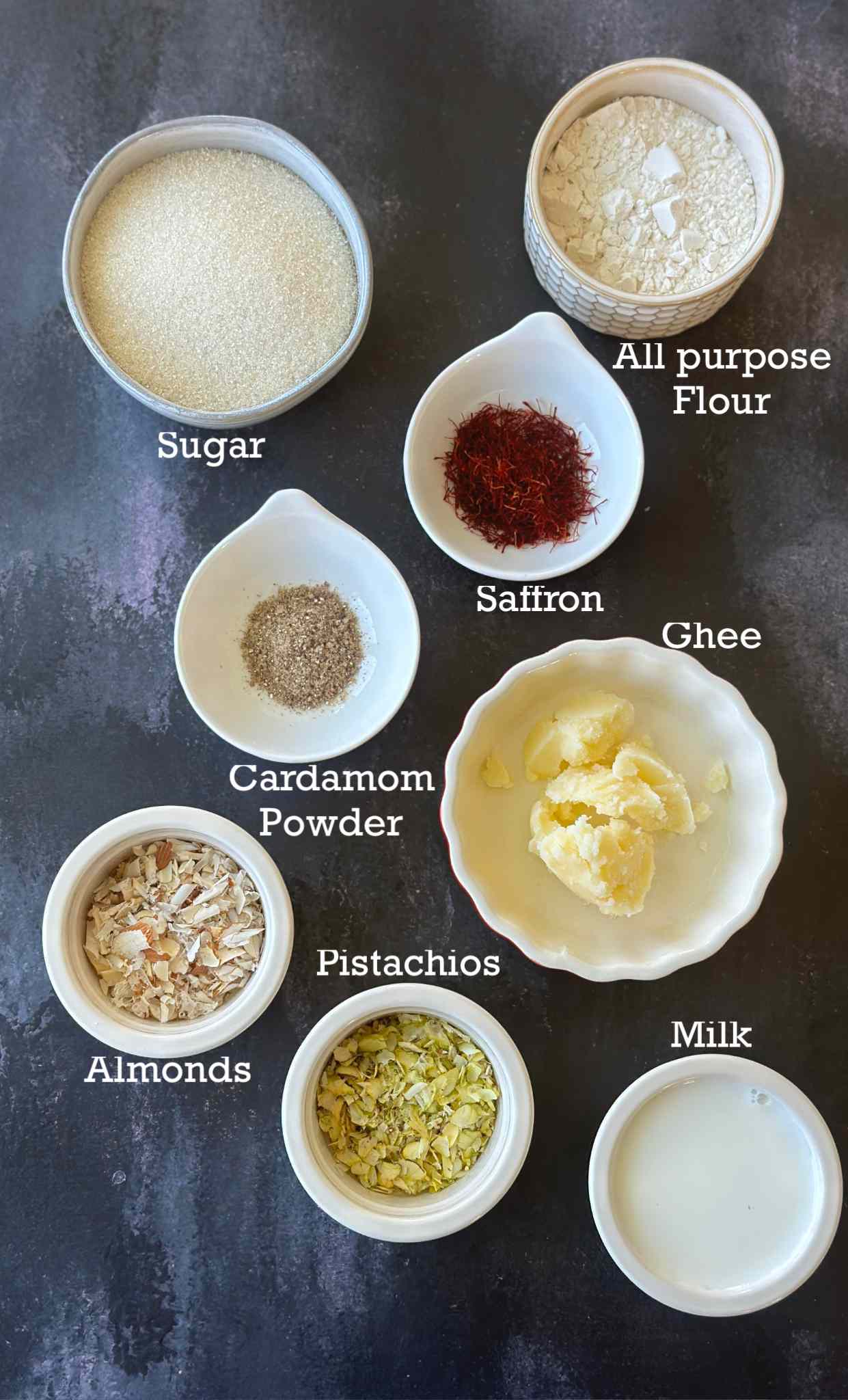 Ingredients to make ice halva in small bowls on a dark surface. 