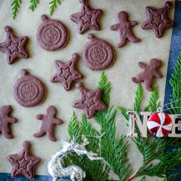 Chocolate Sugar Cookies on a parchment paper with a couple of Christmas ornaments around it.