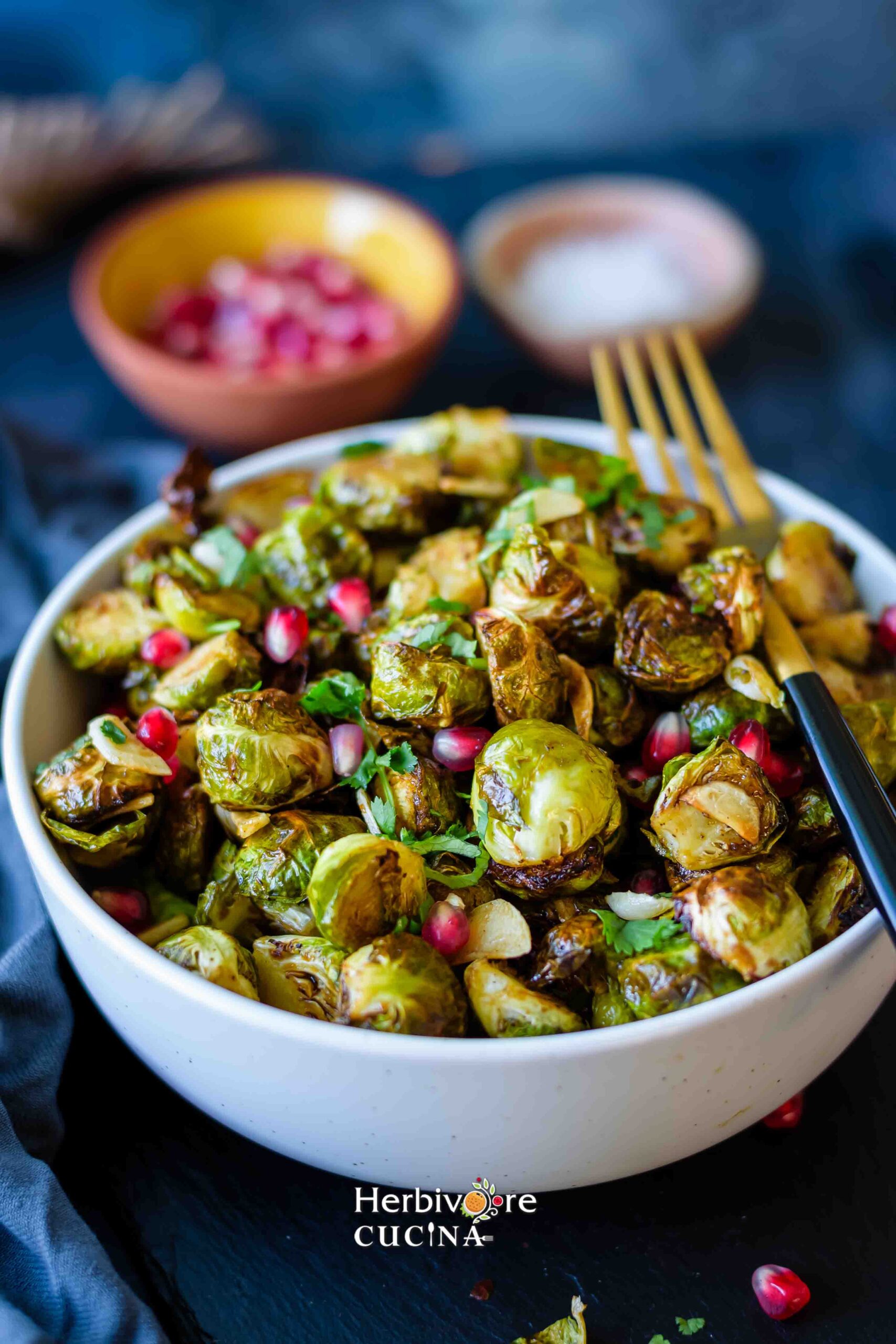 A bowl filled with air fryer Brussels sprouts topped with pomegranate. 