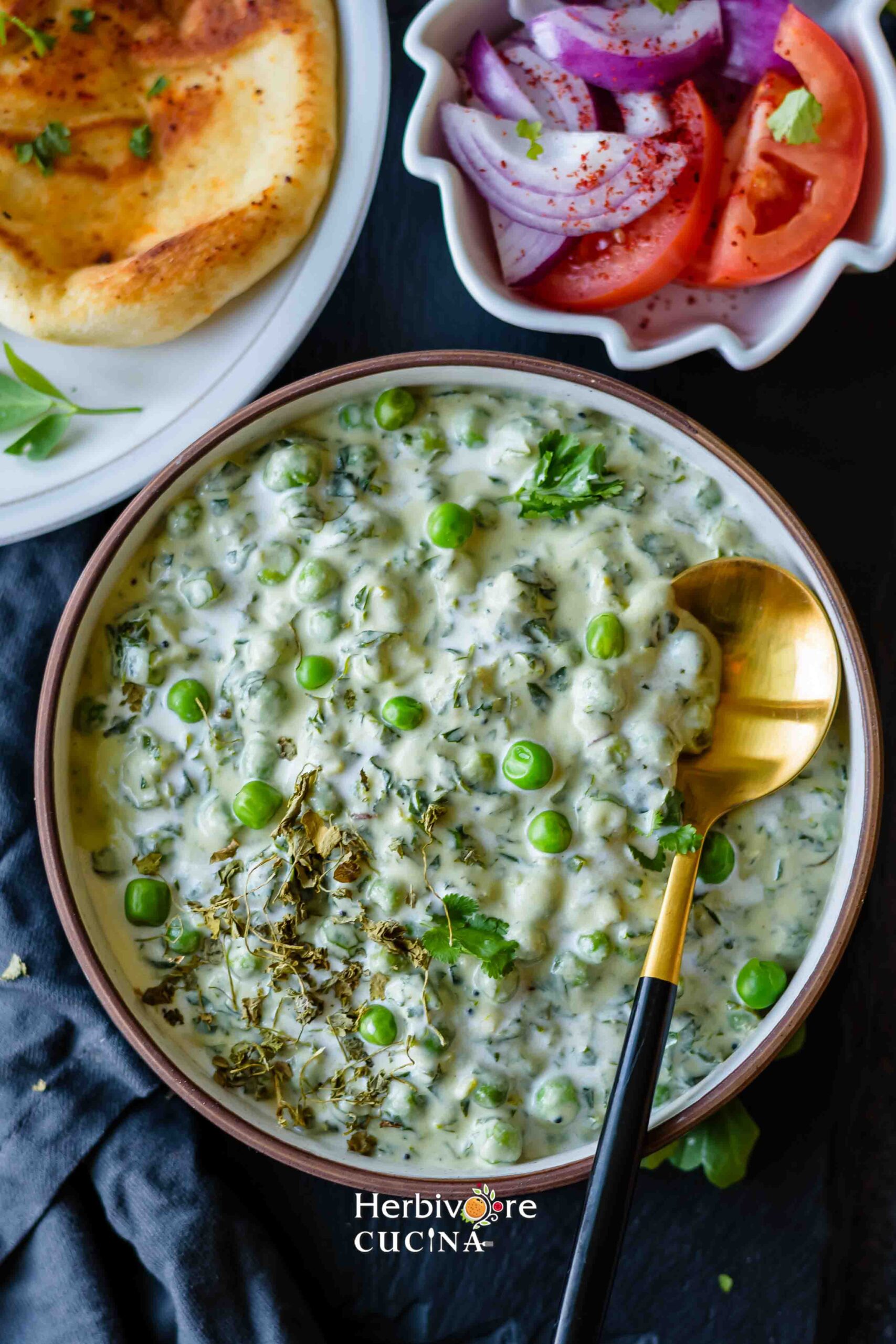 Methi Matar Malai in a bowl with salad and naan on the side in bowls. 